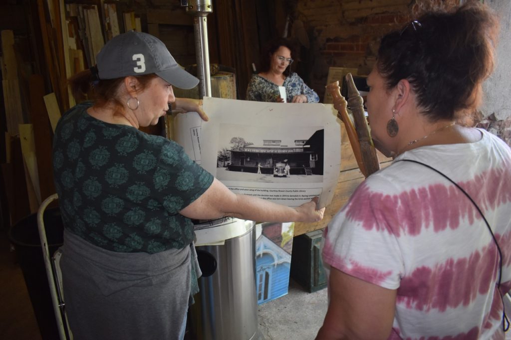 Historic Salisbury Foundation Director Kim Stieg, left, shows Mia Petrea what the ice house used to look like before it became the site of the foundation's second Saturday salvage event. - Chandler Inions
